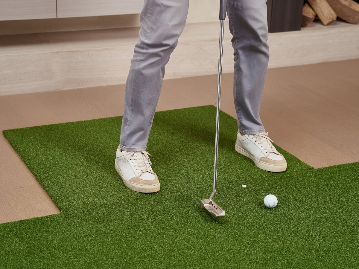 Golfer using Chiputt chipping mat as standing platform for level putting stance as putting mat during indoor practice