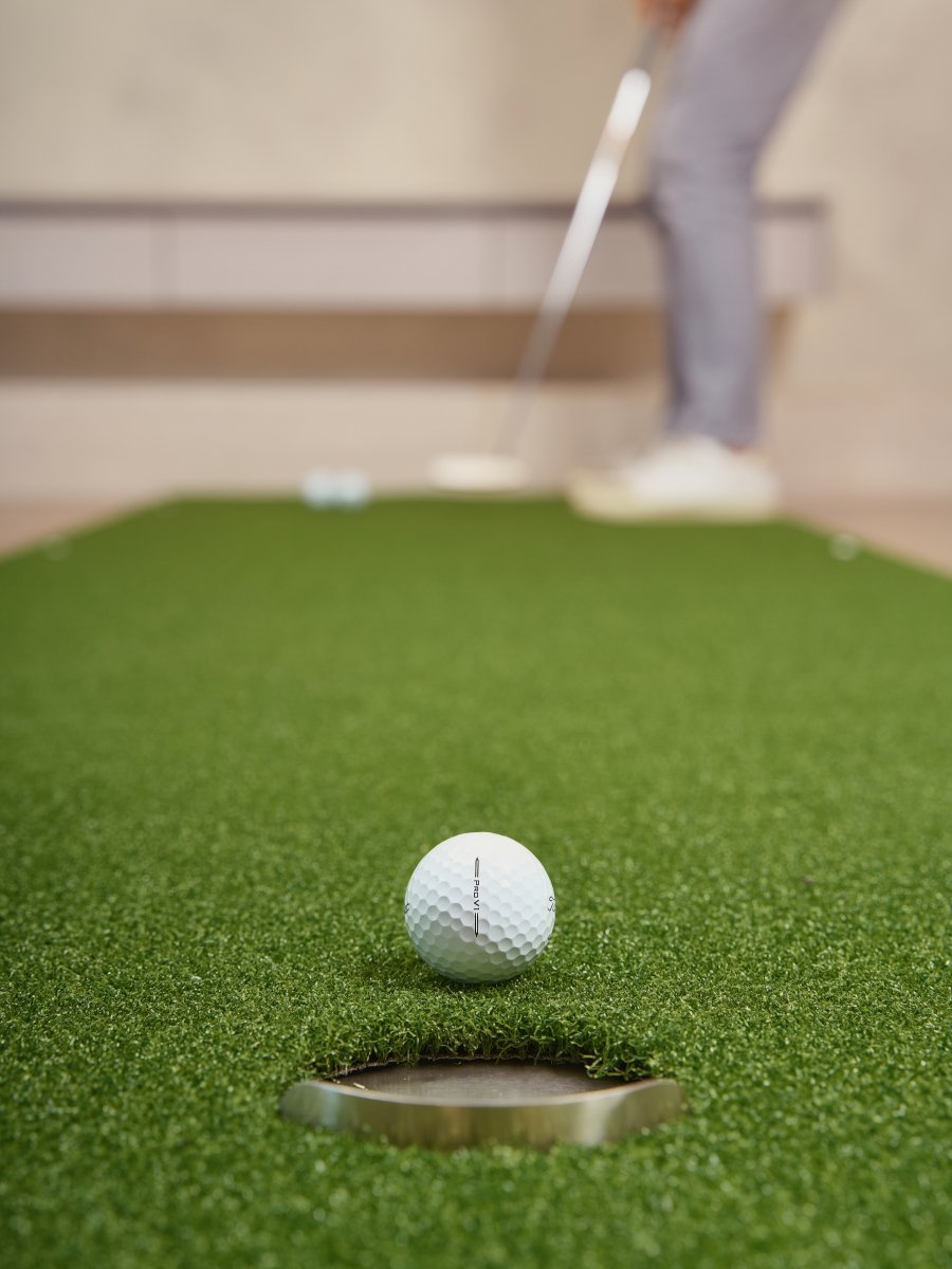 Chiputt putting mat showing successful putt with Titleist Pro V1 ball about to drop into back lip hole during practice