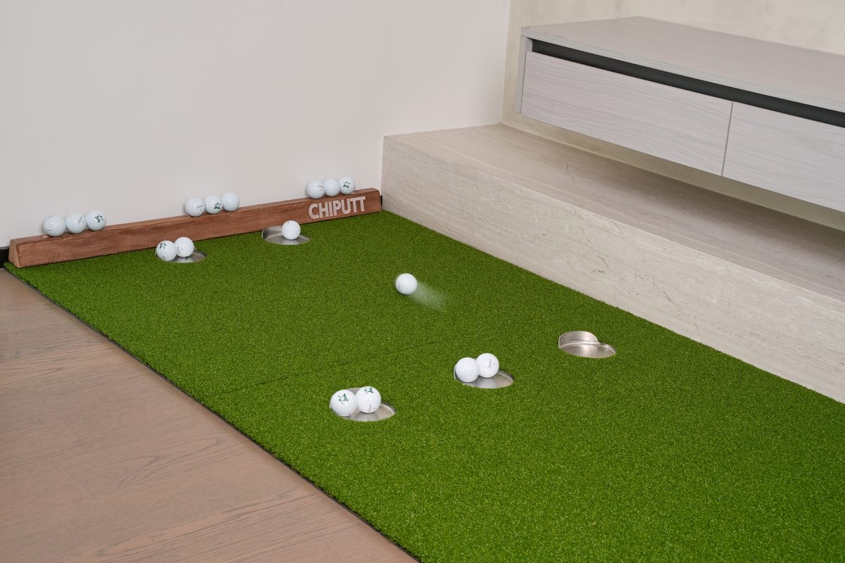 Chiputt putting mat in game mode with multiple golf balls across the five target cups