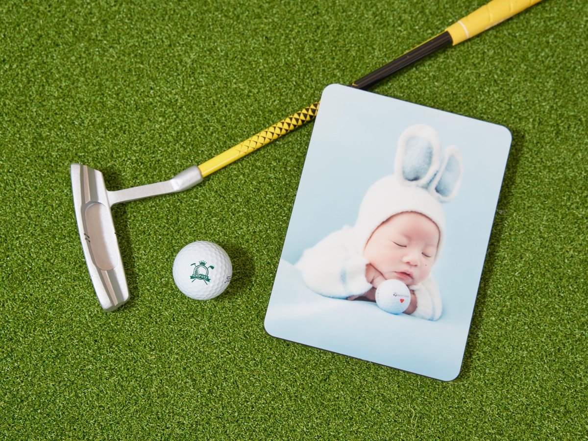 A sentimental image featuring a Chiputt-branded golf ball, a child’s putter, and a personal photo of the founder's son at one month old in a rabbit costume, holding a golf ball with a red heart.