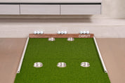 Chiputt putting mat with the new white side rails installed along both edges, framing the five-cup target layout — keeps wayward putts on the mat