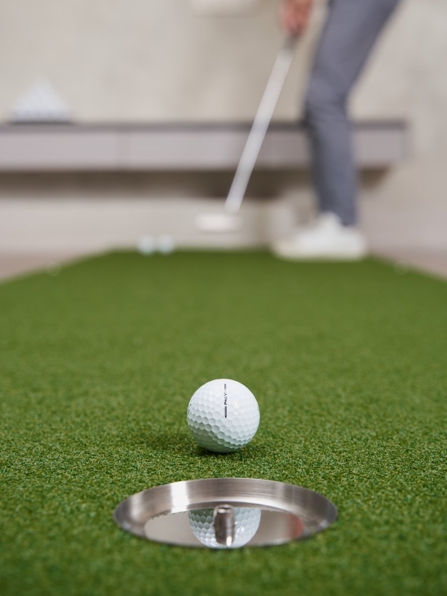 Golfer focused on sinking a putt with a Titleist Pro V1 on the Chiputt mat, highlighting the precision and realistic feel of the practice setup.